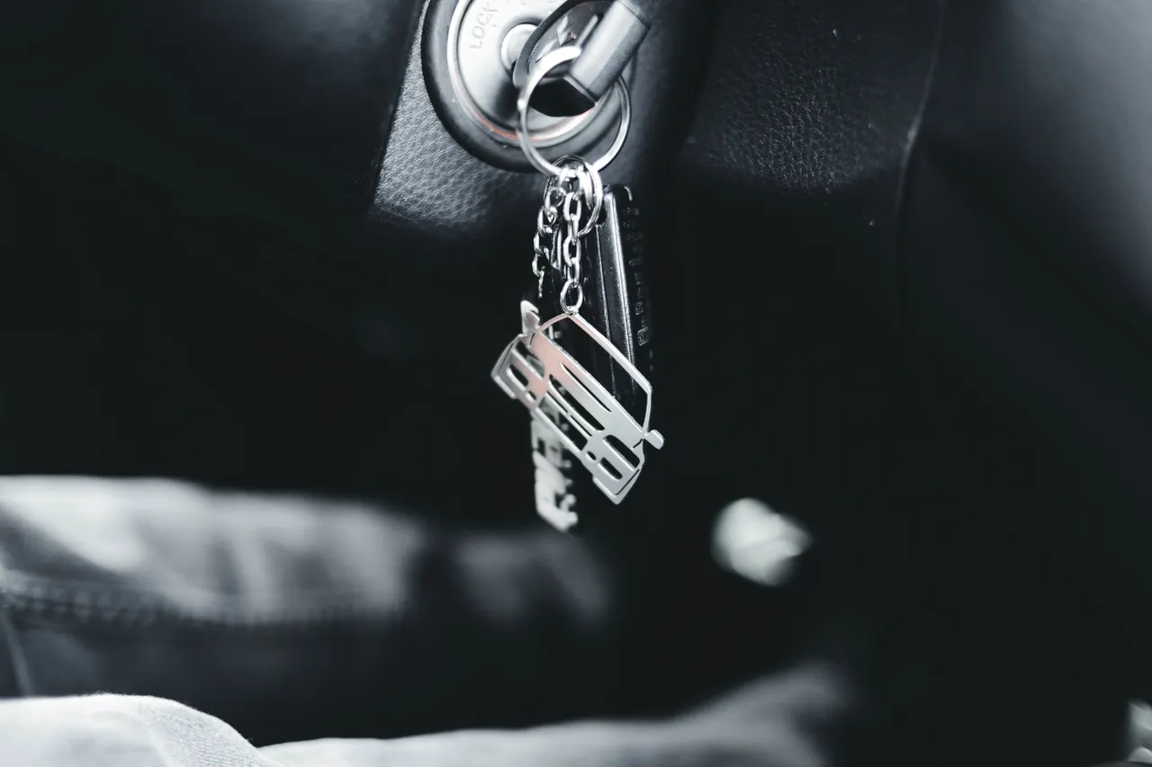 Autoschlüssel auf glänzender Oberfläche – Symbol für Versicherungspflicht und Fahrzeugübergabe in der Autovermietung