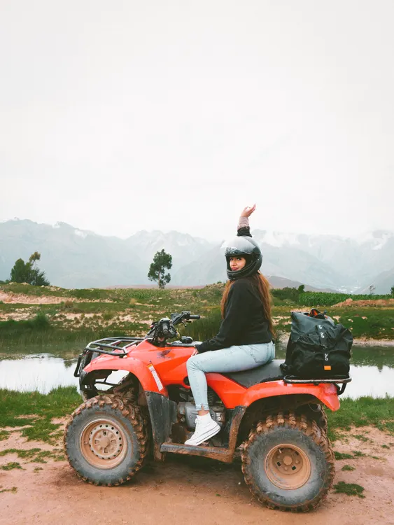 Fahrerin auf einem Quad in bergiger Landschaft – Fahrereinweisung und Führerscheinkontrolle sind vor jedem Mietbeginn Pflicht